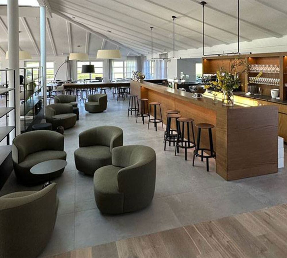 Clubhaus des Golfclub Aachen mit Loungebereich, Bar und großformatigem Fliesenboden