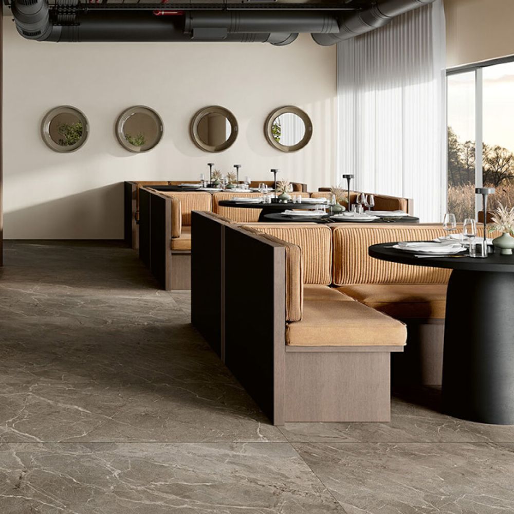 Restaurant mit Sitznischen und großformatigen Bodenfliesen in brauner Marmoroptik