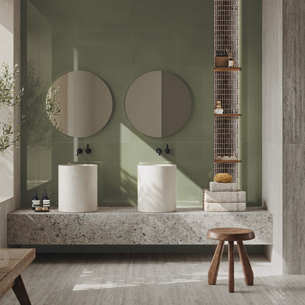 Badezimmer mit grünen Wandfliesen, Travertinoptik und Waschtisch aus Steinoptik mit zwei Säulenbecken